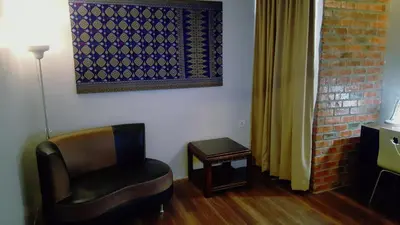 a room with a chair and a painting on the wall at Super 8 Hotel @ Georgetown in George Town