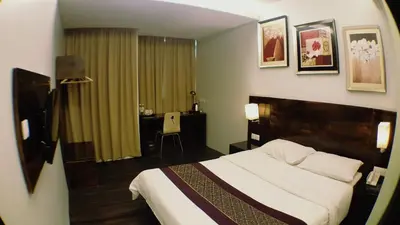 a hotel room with a bed and a desk at Super 8 Hotel @ Georgetown in George Town