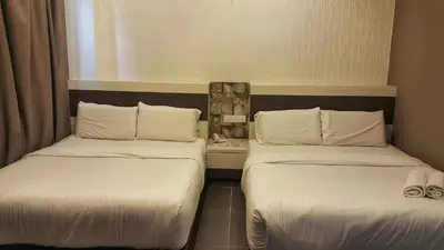 two beds in a hotel room with white sheets at Kampar Boutique Hotel (Kampar Sentral) in Kampar