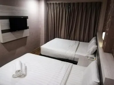 a hotel room with two beds and a tv at Kampar Boutique Hotel (Kampar Sentral) in Kampar