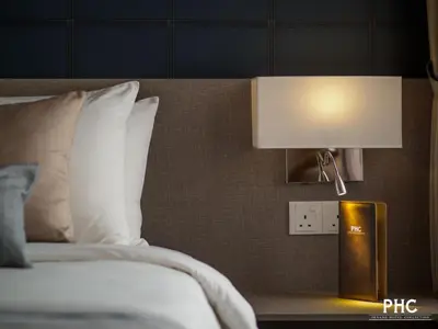 a bedroom with a bed and a lamp on a table at Hutton Suite Hotel Managed by The Ascott Limited in George Town