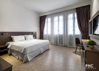 a hotel room with a bed and a television at Hutton Suite Hotel Managed by The Ascott Limited in George Town