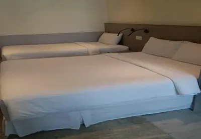 two beds sitting next to each other in a room at Hutton Suite Hotel Managed by The Ascott Limited in George Town