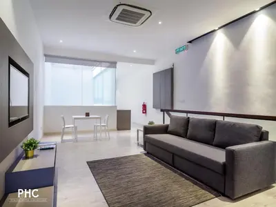 a living room with a couch and a table at Hutton Suite Hotel Managed by The Ascott Limited in George Town