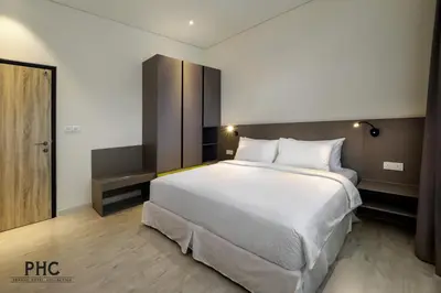 a bedroom with a large white bed in it at Macallum Central Hotel Managed by The Ascott Limited in George Town