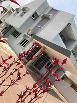 a white building with red flowers in front of it at D’House in Ipoh