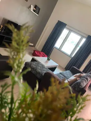 a person sitting on a couch in a living room at D’House in Ipoh