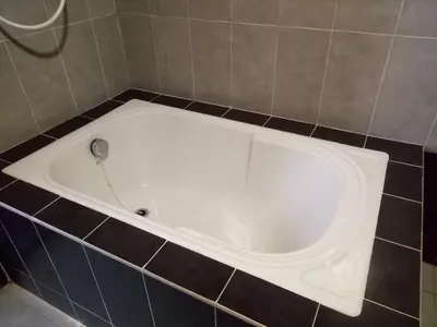 a white bath tub in a tiled bathroom at Hotel Sri Bernam in Sabak Bernam