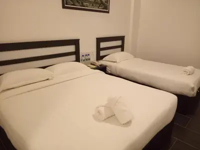 two beds in a hotel room with towels on them at Hotel Sri Bernam in Sabak Bernam