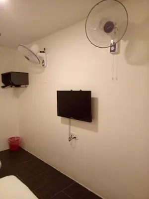 a room with a tv and a fan on a wall at Hotel Sri Bernam in Sabak Bernam