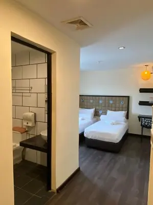 a hotel room with two beds and a mirror at M Season Boutique Hotel Sdn Bhd in Sungai Petani