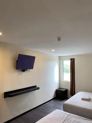 a hotel room with two beds and a tv on the wall at M Season Boutique Hotel Sdn Bhd in Sungai Petani