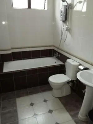 a bathroom with a tub and a toilet and a sink at Bzout rents in Cameron Highlands