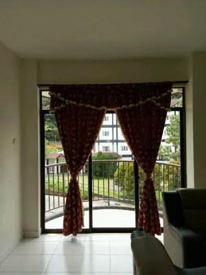 a living room with a large window with a view of a balcony at Bzout rents in Cameron Highlands