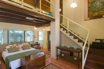 a bedroom with a bed and a staircase in a room at 23 Love Lane Hotel in George Town