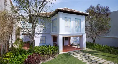 a white house with blue shutters on it at 23 Love Lane Hotel in George Town