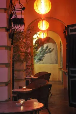 a restaurant with tables and chairs and a wall with a painting at Coffee Atelier in George Town