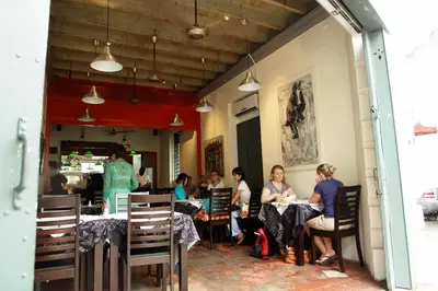 a group of people sitting at tables in a restaurant at Coffee Atelier in George Town
