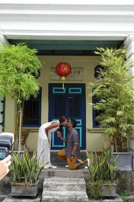 a bride and groom kissing in front of a house at Coffee Atelier in George Town