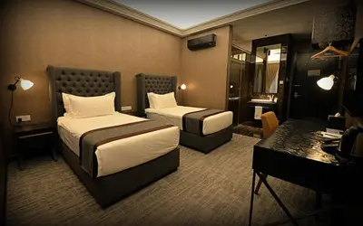 a hotel room with two beds and a desk at 1969 Business Suites Bandar Botani, Ipoh in Ipoh