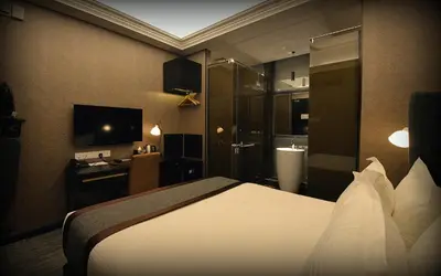 a hotel room with a bed and a bathroom at 1969 Business Suites Bandar Botani, Ipoh in Ipoh