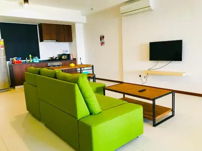 a living room with a green couch and a table at The Landmark by Katana in George Town