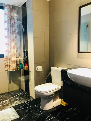 a bathroom with a toilet and a sink and a shower at The Landmark by Katana in George Town