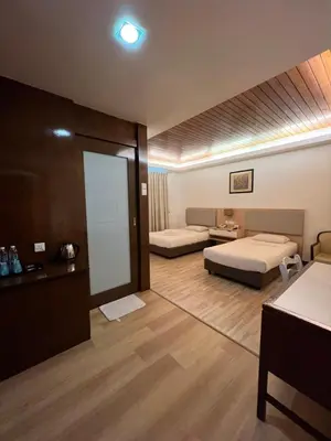 a hotel room with two beds and a mirror at D Eastern Hotel in Ipoh