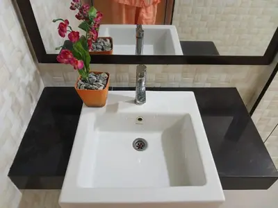 a white sink with a vase of flowers on it at Weng Kong Homestay in Slim River
