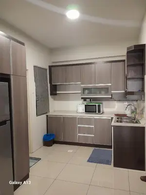 a kitchen with wooden cabinets and a microwave at K. Riverfront apartment in Ipoh