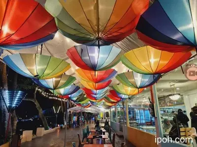 a group of colorful umbrellas hanging from a ceiling at K. Riverfront apartment in Ipoh