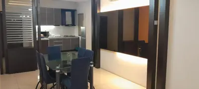 a kitchen with a glass table and blue chairs at K. Riverfront apartment in Ipoh
