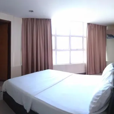 a large white bed in a bedroom with a window at Starview Hotel in Lumut