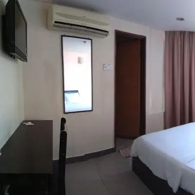 a bedroom with a bed and a television and a window at Starview Hotel in Lumut