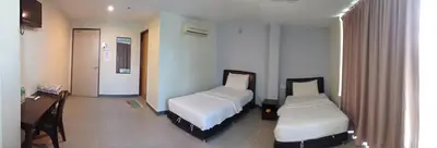a hotel room with two beds and a desk at Starview Hotel in Lumut