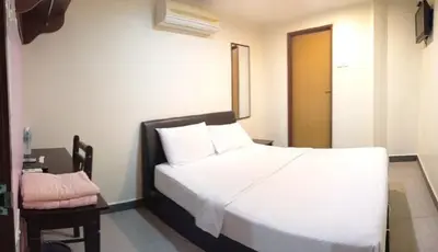 a bedroom with a large white bed and a table at Starview Hotel in Lumut