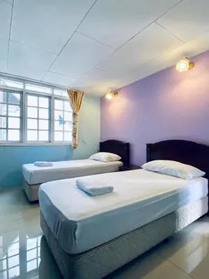 two beds in a room with purple walls and windows at Habitat Fraser's Hill in Bukit Fraser