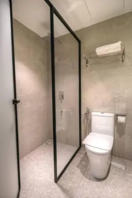 a bathroom with a toilet and a shower with a glass door at The Jerai Hotel Sungai Petani in Sungai Petani