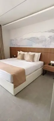 a bedroom with a large bed and a table at The Jerai Hotel Sungai Petani in Sungai Petani