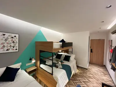 a bedroom with two beds and a wall with aiger at Apple 1 Hotel Queensbay in Bayan Lepas