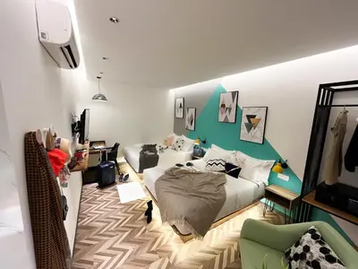 a bedroom with a bed and a green accent wall at Apple 1 Hotel Queensbay in Bayan Lepas