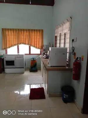 a kitchen with a stove and a window at Homestay Zulaika Kota Aur in Kepala Batas