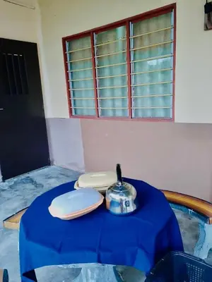 a table with a blue table cloth on top of it at Homestay Zulaika Kota Aur in Kepala Batas