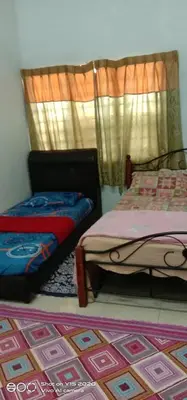 a bedroom with two beds and a rug at Homestay Zulaika Kota Aur in Kepala Batas