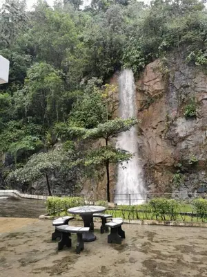 a group of picnic tables in front of a waterfall at Mr.J Homestay in Taiping