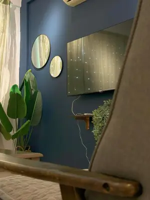 a room with a blue wall with mirrors and plants at Taiping Centre Point Suite 10 by BWC in Taiping