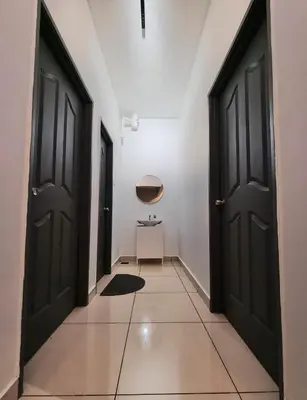 a hallway with two black doors and a table at Taiping Centre Point Suite 10 by BWC in Taiping