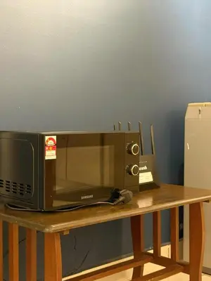 a microwave sitting on top of a wooden table at Taiping Centre Point Suite 10 by BWC in Taiping