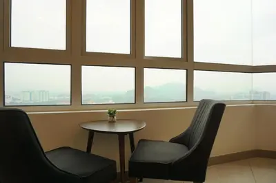a room with two chairs and a table and windows at PM Octagon Ipoh Duplex Suite (4-12paxs) in Ipoh