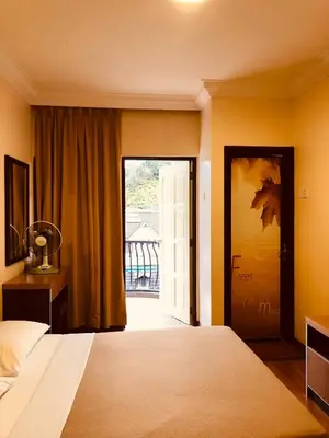 a bedroom with a bed and a door with a window at Hotel Chua Gin in Cameron Highlands